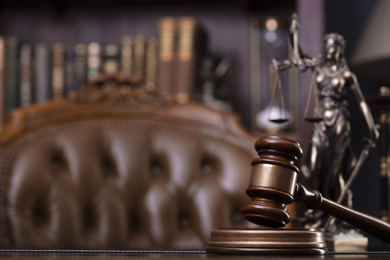 Lady justice with a gavel below a statue of her